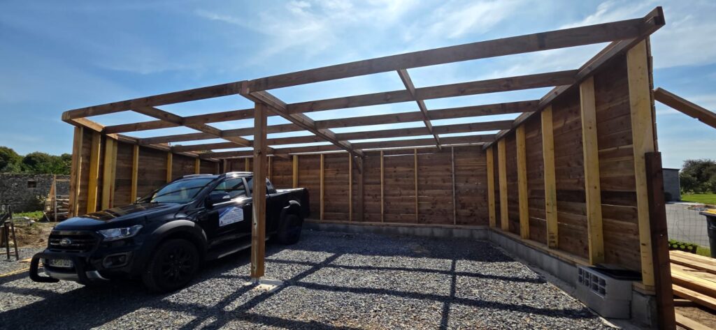 Carport en ossature bois AJL HABITAT, menuiserie extérieure en Normandie, structure sur mesure pour abriter un véhicule.