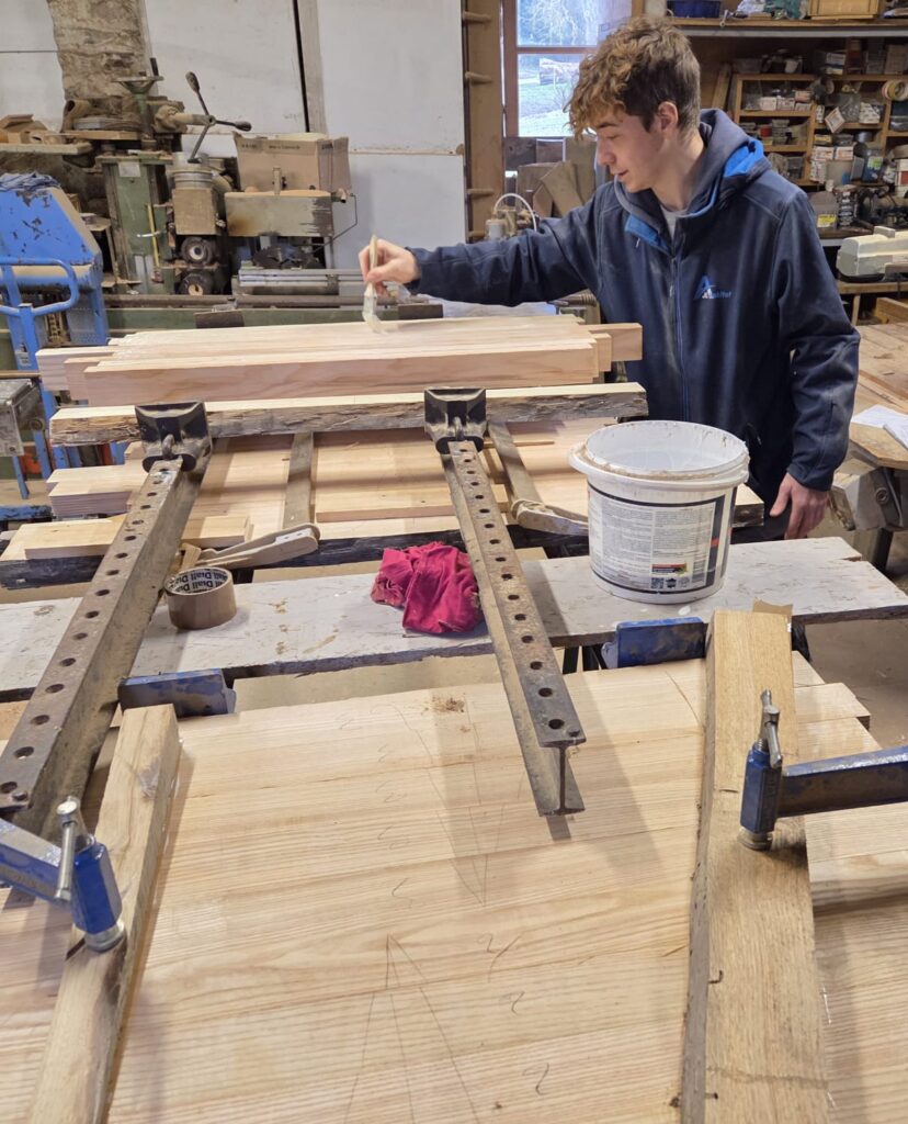 Ossature bois en Normandie : fabrication en atelier AJL HABITAT, Lucas prépare les éléments pour extension ou abri en bois
