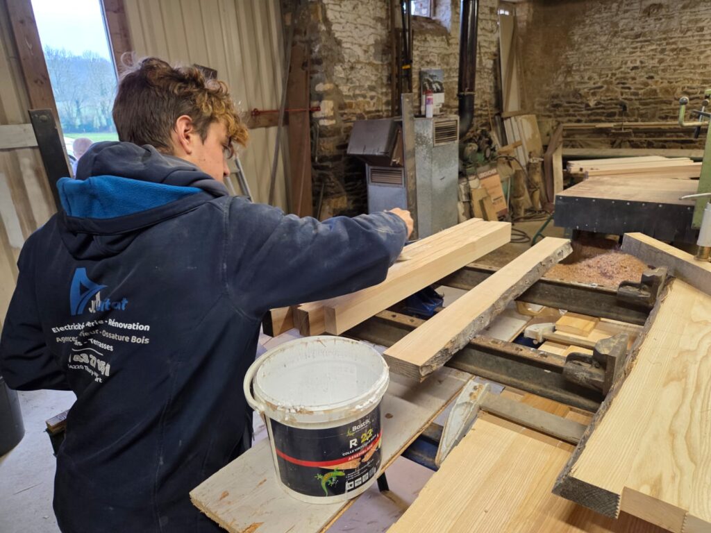 Menuiserie intérieure en Normandie : Lucas AJL HABITAT en atelier, travail du bois et préparation d’éléments sur mesure pour aménagement intérieur.