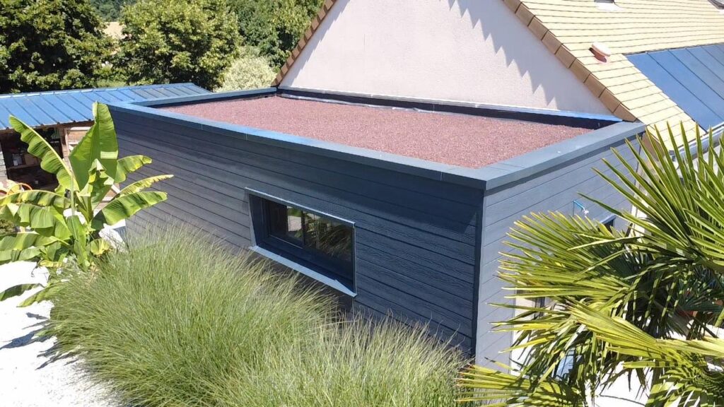 Ossature bois en Normandie : atelier en bois avec bardage gris, finition propre et durable