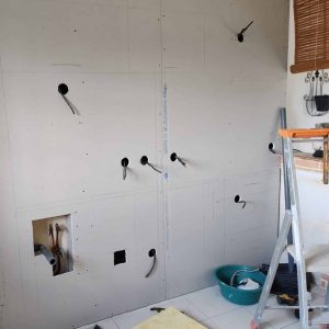 Électricité en Normandie : installation de prises et points électriques sur mur en rénovation, câblage en attente avant finitions.