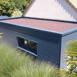 Ossature bois en Normandie : atelier en bois avec bardage gris, finition propre et durable