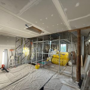 Électricité en Normandie : chantier en rénovation avec câblage, gaines techniques et isolation intérieure en cours de pose.