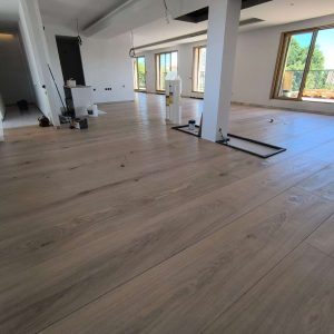 Rénovation intérieure en Normandie : pose de parquet dans une pièce rénovée, finitions propres et sol nivelé.