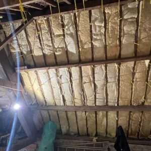 Rénovation intérieure en Normandie : isolation des combles sous toiture, laine minérale posée entre chevrons (chantier en cours).